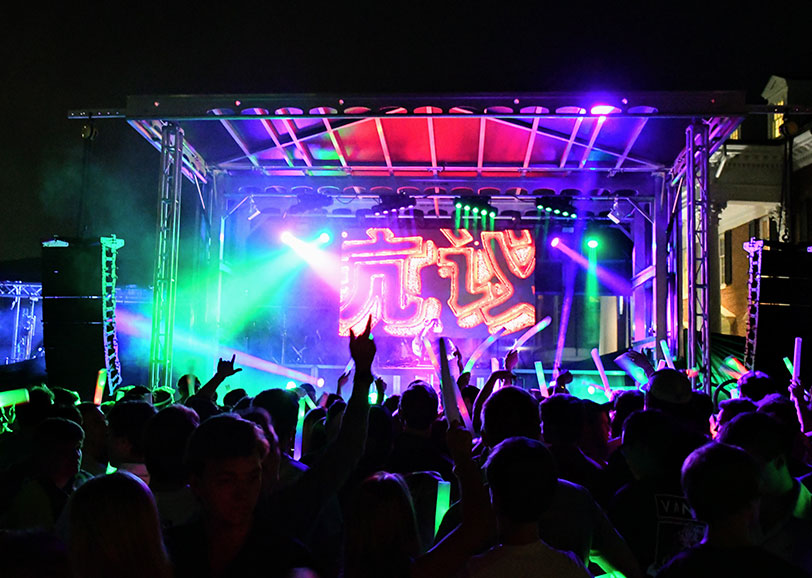 Nighttime outdoor concert on an Apex mobile stage, with stage lighting and an LED screen above a packed crowd
