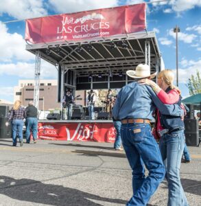 Couple dancing in the street in front of the APEX 2016 mobile stage at a Visit Las Cruces event