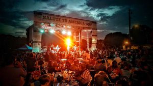 APEX 3224 GEN5 mobile stage at a Salute to America evening concert, with a large seated crowd