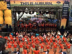 APEX 3224 GEN5 mobile stage at an Auburn University pep rally, with cheerleaders on the deck and the marching band in front
