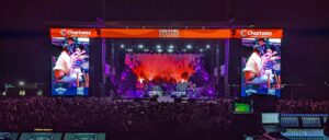 APEX 5040 GEN3 mobile stage at Country Fanfest at night, with video screens on both sides above a large crowd